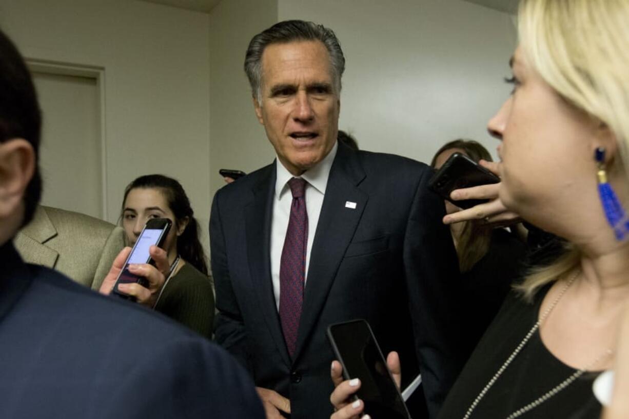 Sen. Mitt Romney, R-Utah, talks to reporters as he walks to attend the impeachment trial of President Donald Trump on charges of abuse of power and obstruction of Congress, Tuesday, Jan. 28, 2020, on Capitol Hill in Washington.