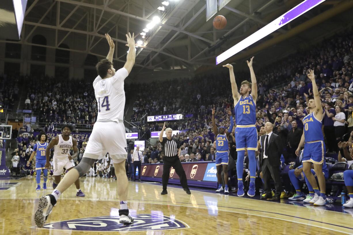 UCLA's Jake Kyman (13) puts up a 3-point shot with seconds left as Washington's Sam Timmins (14) moves in to defend during an NCAA college basketball game Thursday, Jan. 2, 2020, in Seattle. Kyman made the shot and UCLA won 66-64.