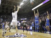 UCLA's Jake Kyman (13) puts up a 3-point shot with seconds left as Washington's Sam Timmins (14) moves in to defend during an NCAA college basketball game Thursday, Jan. 2, 2020, in Seattle. Kyman made the shot and UCLA won 66-64.