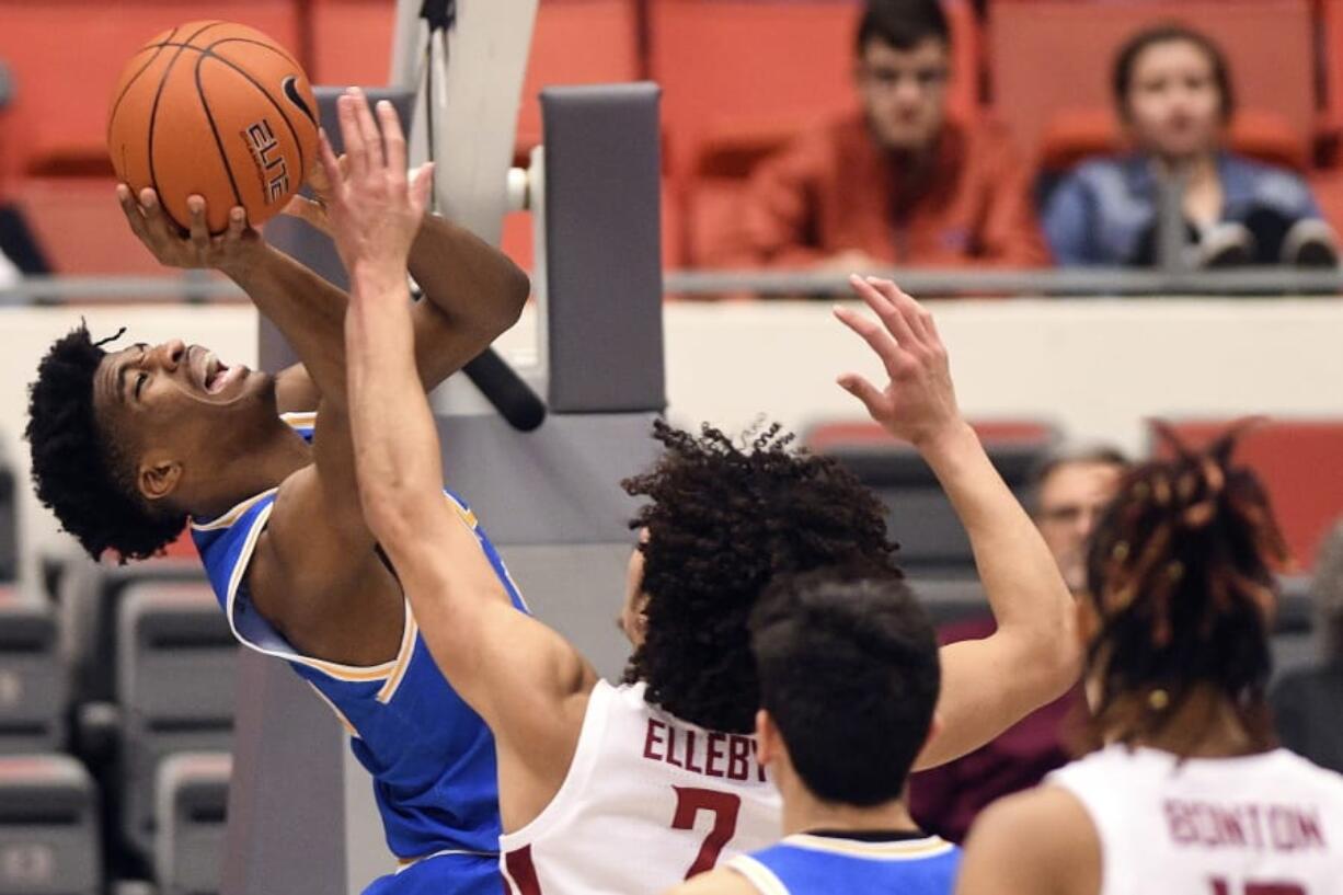 UCLA guard Chris Smith (5) attempts a shot under the basket as Washington State forward CJ Elleby (2) defends in the first half of an NCAA college basketball game, Saturday, Jan. 4, 2020, in Pullman, Wash.