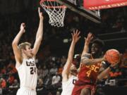 Southern California&#039;s Daniel Utomi (4) passes away from the basket to avoid Oregon State&#039;s Kylor Kelley (24) and Tres Tinkle (3) during the first half of an NCAA college basketball game in Corvallis, Ore., Saturday, Jan. 25, 2020.