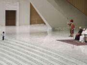 A child walks in front of Pope Francis during the weekly general audience in the Paul VI Hall at the Vatican, Wednesday, Jan. 22, 2020.