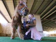 Kaylee Taylor, 9, a fourth-grader, uses a  stethoscope to listen to the heart of Fable, a miniature horse, with the help of Justin Norris, education coordinator at the Helen Woodward Animal Center, during the one-day veterinarian camp at the center Saturday in Rancho Santa Fe, Calif.