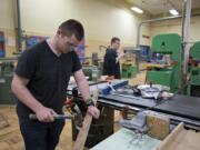 Ridgefield High School sophomore Tynan Henderson, 16, removes nails from boards while working during wood tech class in February 2020 — not long before students went to remote schooling.