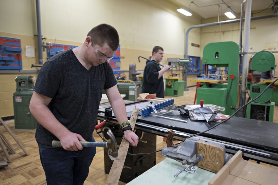 Ridgefield High School sophomore Tynan Henderson, 16, removes nails from boards while working during wood tech class in February 2020 — not long before students went to remote schooling.