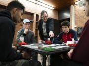 Paul Gutterman, standing at center, who is a tax professor at the University of Minnesota and an avid bridge player, gives a group of honors students guidance on their finished bridge game Feb. 10 during their Monday night gathering at Middlebrook Hall at the University of Minnesota in Minneapolis, Minn.