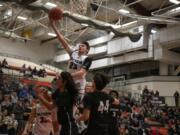 Skyview’s Kyle Gruhler (23) goes up for a layup over two Jackson defenders at Battle Ground High School on Saturday evening, Feb. 29, 2020.