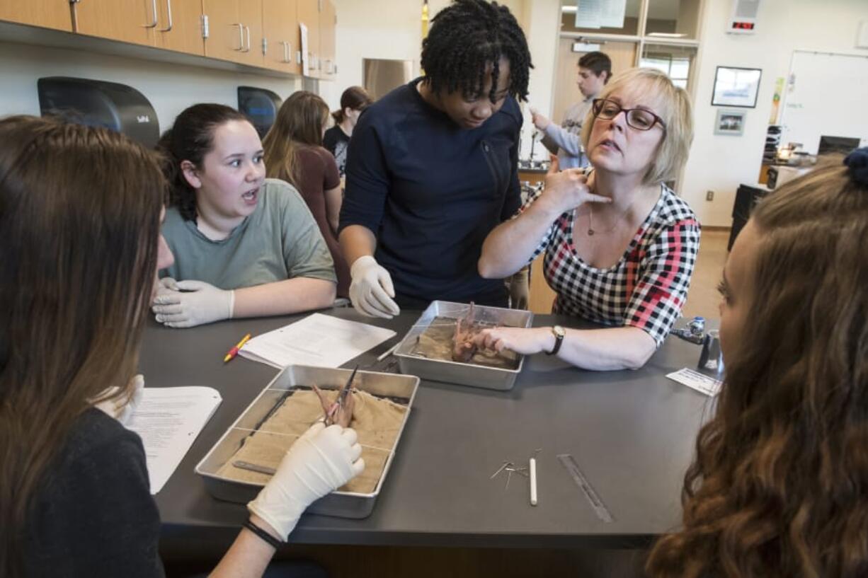 Kamryn Martin, 14, from left, Gracy Lewellen, 15, Kayalin Smith, medical science teacher Nelean Warndahl and Tina Harmon, 15, work together to dissect a fetal pig during a medical science class in April at Woodland High School.