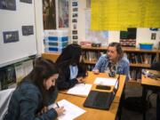 Woodland High School seniors Rachel Young, left, and Ariana Vega, center, talk with teacher Shari Conditt during an advanced government class at Woodland High School in early 2020. Experts say allowing students to discuss controversial subjects in the classroom can build more critical readers, thinkers and voters.