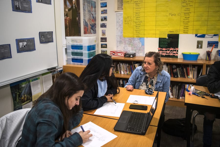 Woodland High School seniors Rachel Young, left, and Ariana Vega, center, talk with teacher Shari Conditt during an advanced government class at Woodland High School in early 2020. Experts say allowing students to discuss controversial subjects in the classroom can build more critical readers, thinkers and voters.