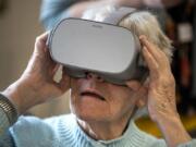 Bonaventure of Vancouver resident Patricia Hulslander tries out a photographic tour of Paris&#039;s Notre-Dame Cathedral with a virtual reality headset at the retirement community in Vancouver. Fort Vancouver Regional Libraries worked with Bonaventure of Vancouver to provide residents with the virtual vacation activity.