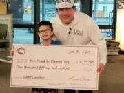 NORTHWEST: Benjamin Franklin Elementary School second-grader Keoni Ching raised $4,015 to help pay off his classmates&#039; outstanding balances on their lunch accounts. He presented the check to Principal Woody Howard on Jan.