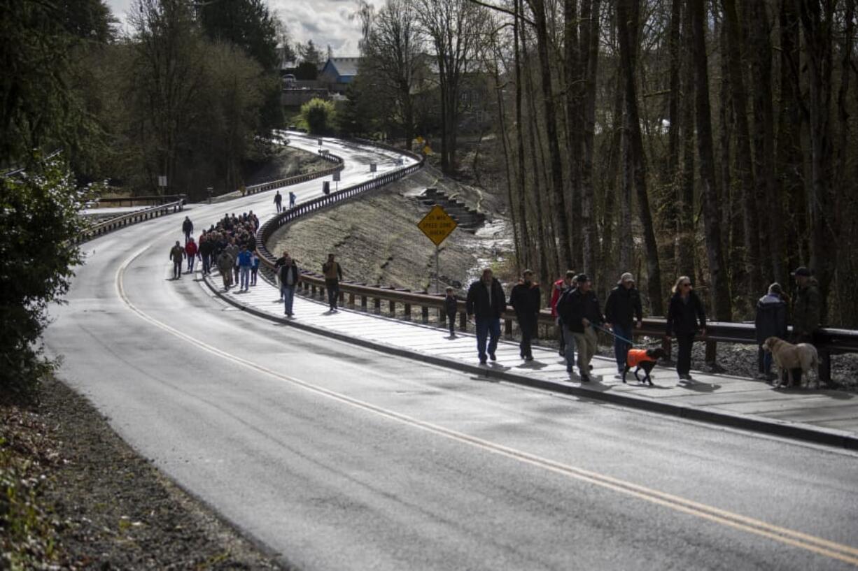 Walkers make their way down Main Avenue before the ribbon cutting ceremony Friday to celebrate the completion of the John Hudson Trail over the remodeled Gee Creek Crossing at the Ridgefield National Wildlife Refuge.