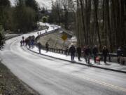 Walkers make their way down Main Avenue before the ribbon cutting ceremony Friday to celebrate the completion of the John Hudson Trail over the remodeled Gee Creek Crossing at the Ridgefield National Wildlife Refuge.