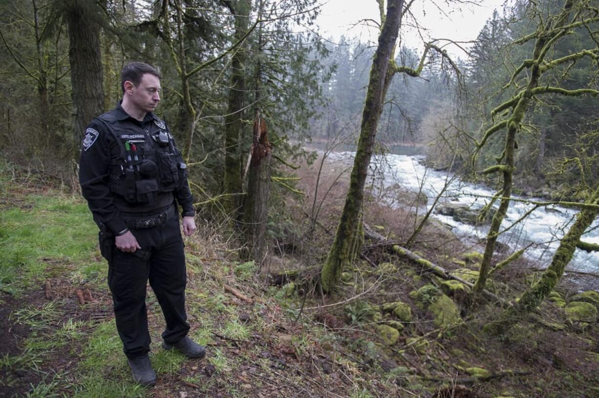 Washougal police Officer Francis Reagan pauses Thursday near the spot along the Washougal River where he rescued a woman from the water.