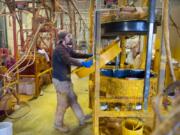 Fiberglass technician Brad Cherry takes one side of a life ring cabinet out of the mold to finish cooling at Cheyenne Manufacturing in Vancouver. The company specializes in storage cases for marine safety products, and is currently embarking on a fundraising project to build and install loaner life jacket cabinets in state parks.