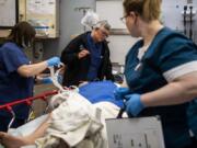 Trauma surgeon Dr. Tracy Timmons, center, updates a patient on his injuries at PeaceHealth Southwest Medical Center in Vancouver. Timmons previously worked in trauma in Baltimore, where she had much less time to spend with patients, because of how busy her schedule was.