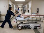 Primary registered nurse Brynne Sarigan wheels a patient to get CT scans at PeaceHealth Southwest Medical Center in Vancouver.