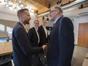 Sean McClain, founder and CEO of AbSci, left, greets Gov. Jay Inslee at the AbSci offices in downtown Vancouver on Thursday. Inslee helped the company finance a move to Vancouver in 2016, and AbSci has seen massive growth since then. Also pictured are AbSci&#039;s Johan Kers, second from left, and Fred Larimore.