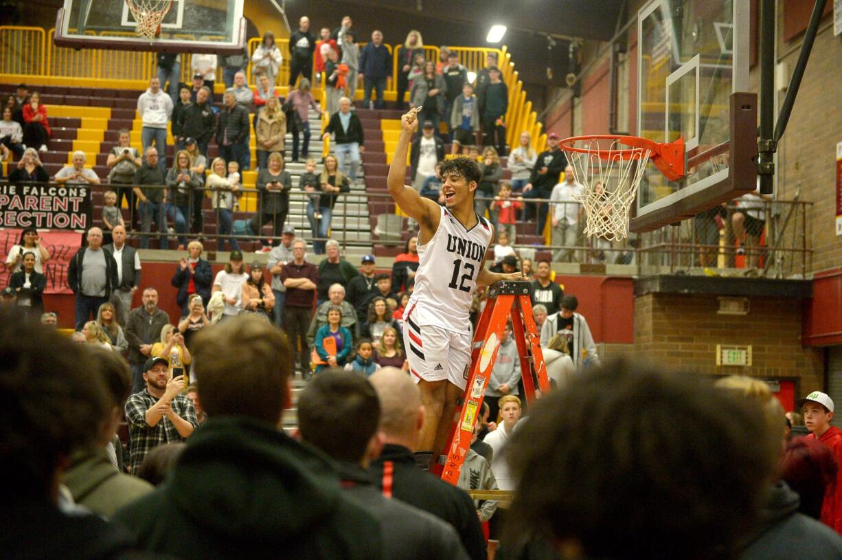 Union junior Ariya Briscoe cuts a piece of the game net after the 4A bi-district championship game against Battle Ground at Prairie High School on Saturday, February 22, 2020. Union beat Battle Ground 82-57.