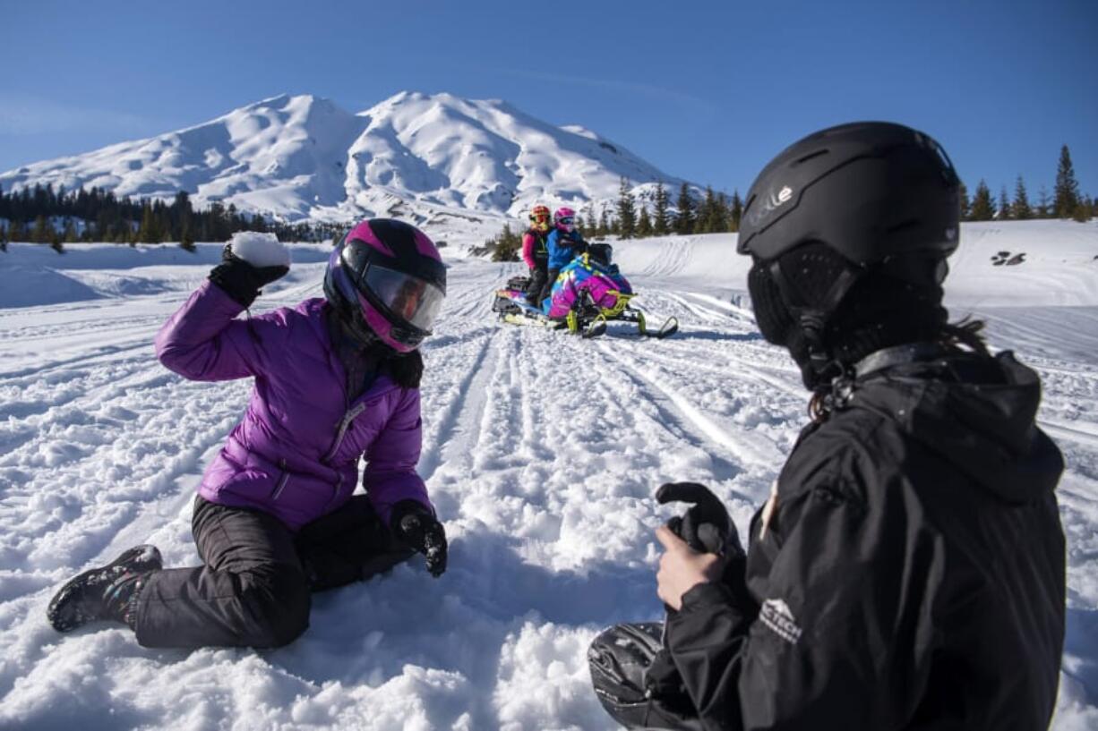 Washington State School for the Blind sixth-grader Li Ling Joosten, left, and eighth-grader Rory Opheikens play in the snow Thursday as they take a break from snowmobiling at Marble Mountain Sno-Park at the base of Mount St. Helens. &quot;The idea is to expose the students to all of these different activities so that when they move on they can do activities on their own,&quot; said Corey Grandstaff, residential program manager. At top, seventh-graders Pavel Anisimov, left, and Jacob Cahill chat as they get ready to head out on the day trip.