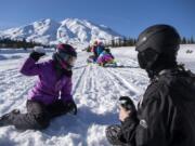 Washington State School for the Blind sixth-grader Li Ling Joosten, left, and eighth-grader Rory Opheikens play in the snow Thursday as they take a break from snowmobiling at Marble Mountain Sno-Park at the base of Mount St. Helens. &quot;The idea is to expose the students to all of these different activities so that when they move on they can do activities on their own,&quot; said Corey Grandstaff, residential program manager. At top, seventh-graders Pavel Anisimov, left, and Jacob Cahill chat as they get ready to head out on the day trip.