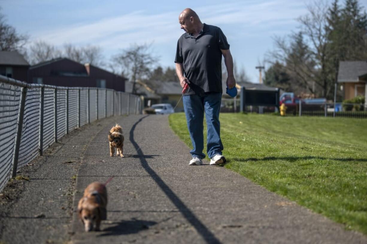 Bill Hoover walks his dogs Daisey, front, and Gotcha, back, near his apartment in Vancouver. CDM Caregiving Services Living with Dignity program helped Hoover pay for medical care for his dog Gotcha when she fell ill last year.