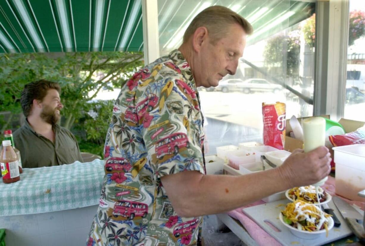 Skip Ballweber, founder and longtime owner of the Wiener Wagon, prepares a hot dog in 2001. Ballweber recently passed away, leaving behind a decadeslong legacy in the Vancouver community.