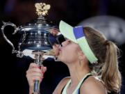 Sofia Kenin of the U.S. kisses the Daphne Akhurst Memorial Cup after defeating Spain's Garbine Muguruza in the women's singles final at the Australian Open tennis championship in Melbourne, Australia, Saturday, Feb. 1, 2020.