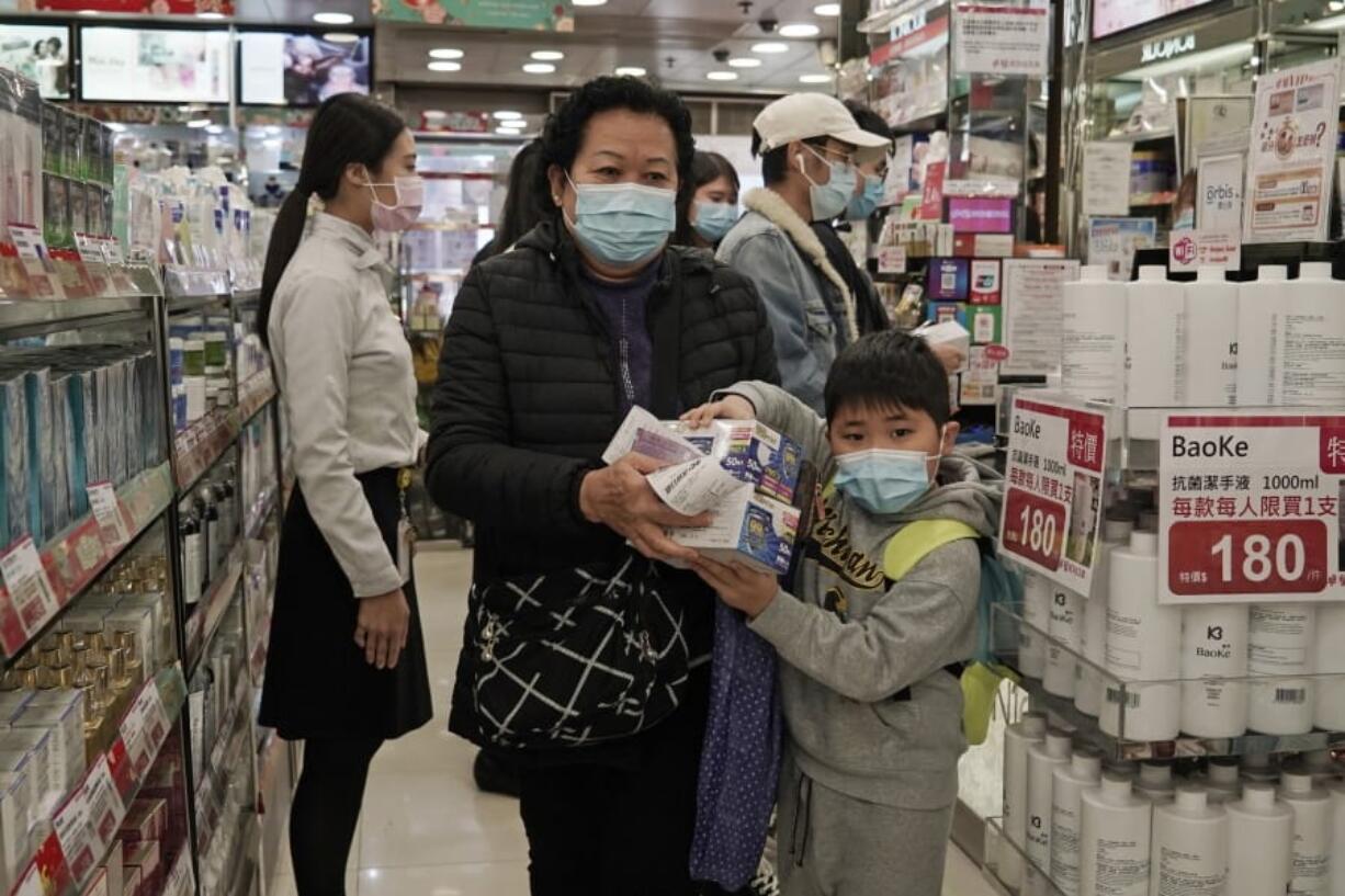 A woman a boy purchase face masks in Hong Kong, Saturday, Feb, 1, 2020. China&#039;s death toll from a new virus has risen over 250 and a World Health Organization official says other governments need to prepare for&quot;domestic outbreak control&quot; if the disease spreads.