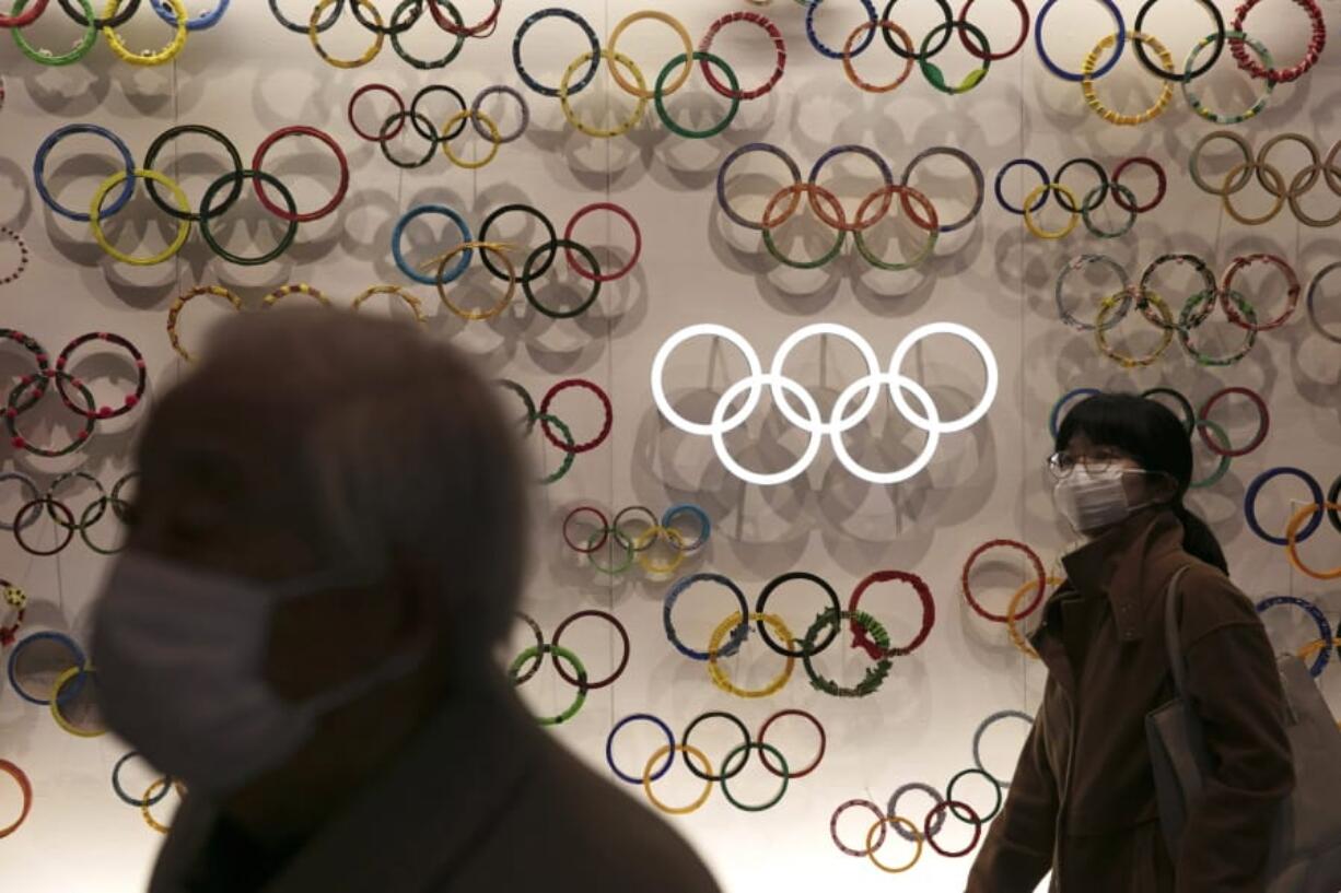 Two people wear masks as they visit the newly opened Japan Olympic Museum located near the New National Stadium, Sunday, Feb. 23, 2020, in Tokyo. (AP Photo/Jae C.