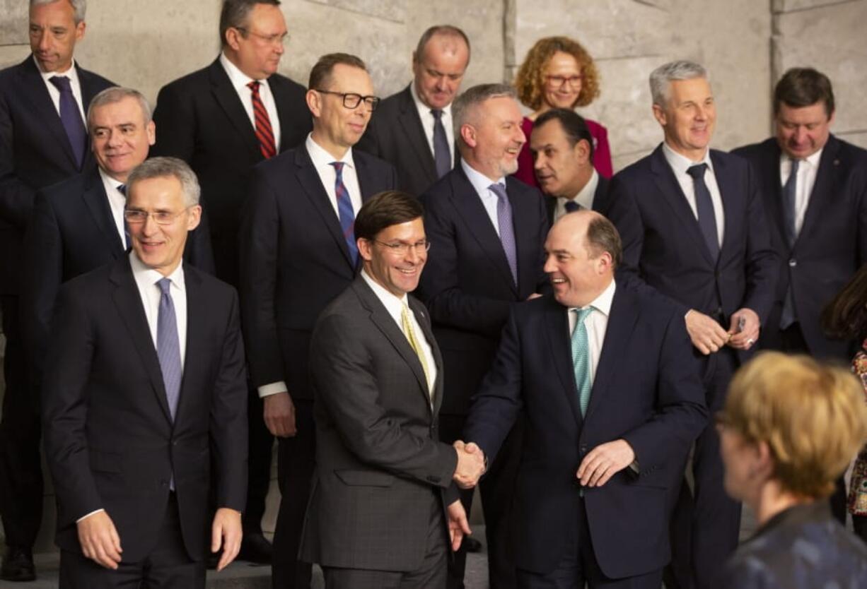 U.S. Secretary for Defense Mark Esper, front center, shakes hands with British Defense Minister Ben Wallace during a group photo of NATO defense ministers at NATO headquarters in Brussels, Wednesday, Feb. 12, 2020. NATO ministers, in a two-day meeting will discuss building stability in the Middle East, the Alliance&#039;s support for Afghanistan and challenges posed by Russia&#039;s missile systems.