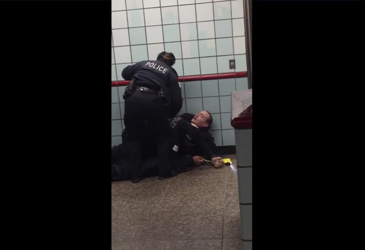 This image from cellphone video shows Chicago police officers trying to apprehend a suspect in a downtown train station.