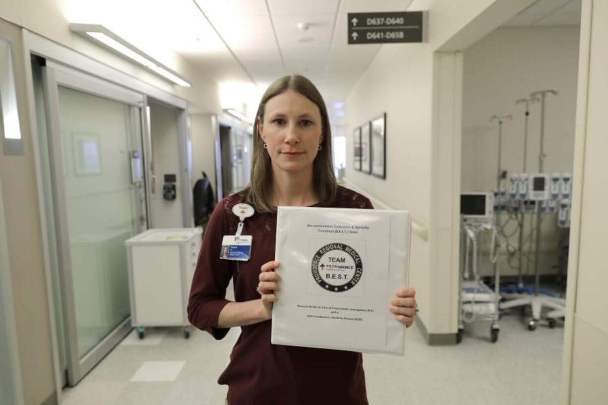 Sarah Wilkerson, manager of infection prevention at Providence Regional Medical Center in Everett, holds Jan. 23 a binder of policies for treating infectious patients. Wilkerson was part of the team that treated the first U.S. patient infected with the new virus from China. (Ted S.