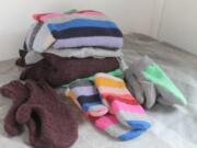 Three pairs of handmade mittens were each constructed from sweaters using slightly different techniques.