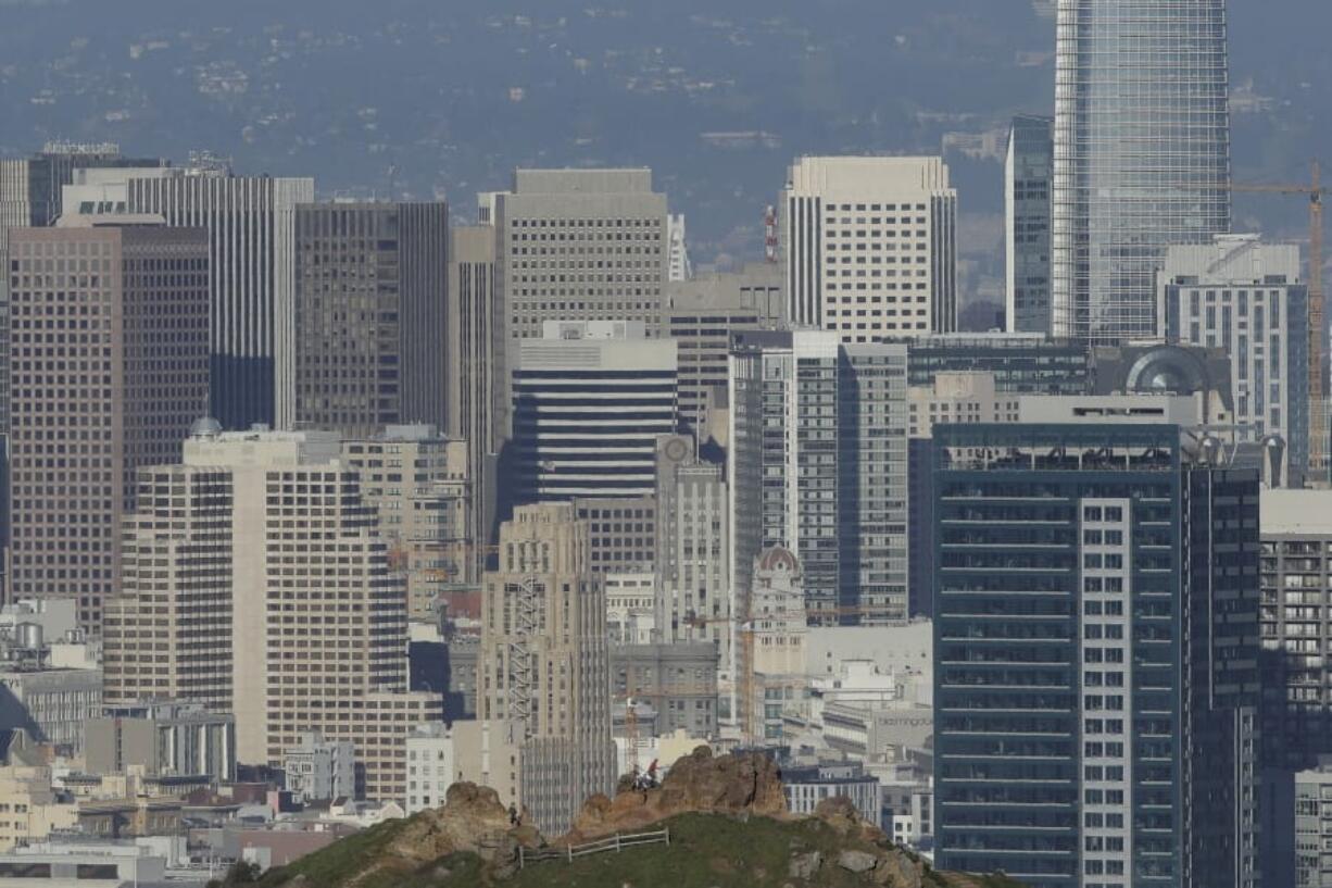 A man climbs a bluff on Corona Heights in front of the skyline seen from Tank Hill in San Francisco, Wednesday, Feb. 26, 2020. California officials are bracing for the potential of another drought and an early and more intense wildfire season amid a record-breaking warm and dry February.