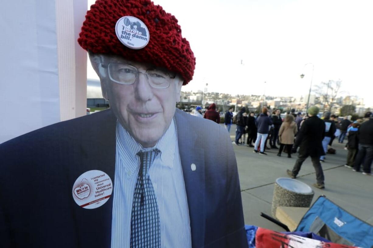 A cardboard cutout of Democratic presidential candidate Sen. Bernie Sanders I-Vt., is displayed at a booth promoting universal health care outside a campaign event for Sanders in Tacoma, Wash., Monday, Feb. 17, 2020. (AP Photo/Ted S.