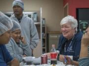 Karen Diefendorf, second from right, director of Chaplain Services at Tyson Foods, talks with employees in 2018 at the company&#039;s Berry Street poultry plant in Springdale, Ark. The company deploys a team of more than 90 chaplains to comfort and counsel employees at its plants and offices. The program began in 2000.