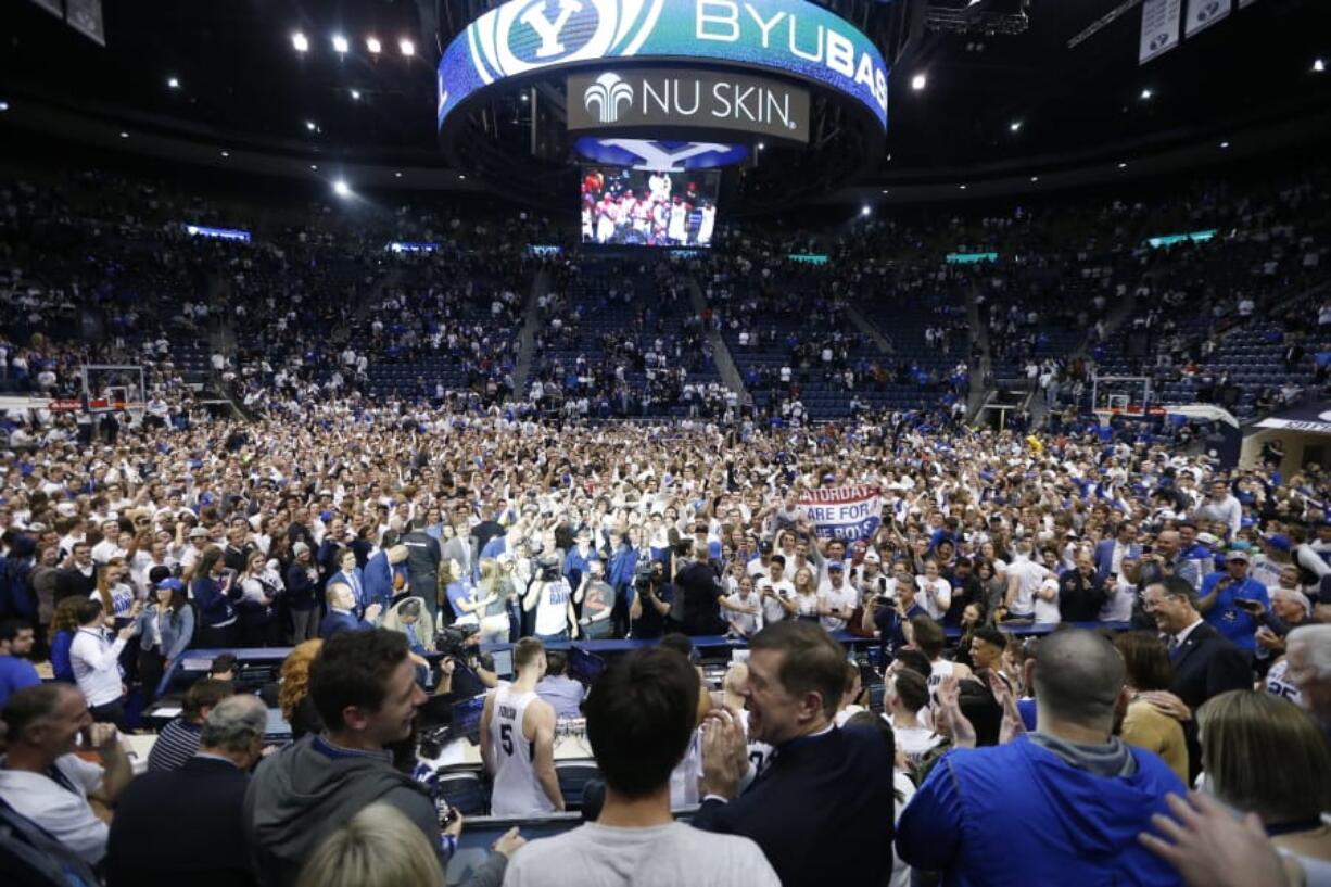 BYU students and fans celebrate on the court following BYU&#039;s 91-78 victory over Gonzaga in an NCAA college basketball game Saturday, Feb. 22, 2020, in Provo, Utah.