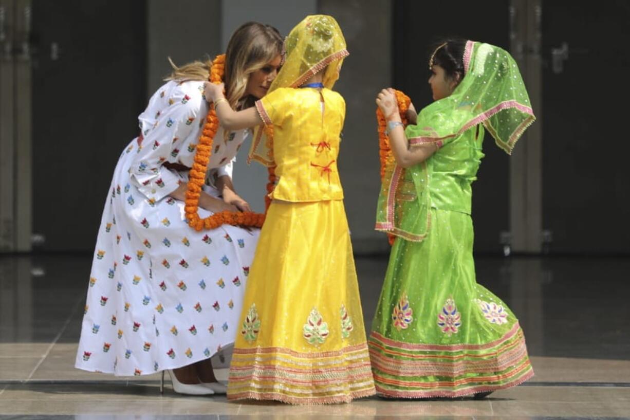 U.S. first lady Melania Trump is garlanded by two children at Sarvodaya Co-Educational Senior Secondary School in New Delhi, India, Tuesday, Feb. 25, 2020.