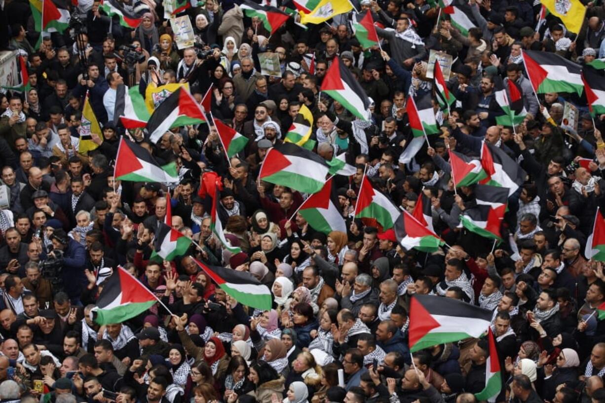 Palestinians wave national flags as they take part in a protest against President Donald Trump&#039;s Mideast initiative in the West Bank city of Ramallah. Tuesday, Feb. 11, 2020. Palestinian President Mahmoud Abbas plans to deliver a speech at the U.N. later in the day, but members will not be voting on a draft resolution. Palestinian officials denied the resolution had been pulled, but diplomats said many members, including European countries, rejected the language in a draft that had circulated.