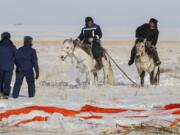 Kazakh shepherds ride near a parachute close to the place where Russian Soyuz MS-13 space capsule landed about 150 km (90 miles) south-east of the Kazakh town of Zhezkazgan, Kazakhstan, Thursday, Feb. 6, 2020. A Soyuz space capsule with U.S. astronaut Christina Koch, Italian astronaut Luca Parmitano and Russian cosmonaut Alexander Skvortsov, returning from a mission to the International Space Station landed safely on Thursday on the steppes of Kazakhstan.