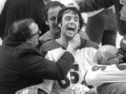 In this Feb. 22, 1980, photo, Team USA goaltender Jim Craig got a hug from goalie coach Warren Strelow in the moments after defeating the Soviet Union during the medal-round of the Winter Olympics in Lake Placid, N.Y. Tourism is a $1.2 billion industry in the Lake Placid region, much of it still fueled by the memory of the U.S. hockey team beating the Soviet Union as the &quot;Miracle on Ice&quot; highlight of the 1980 Olympic Games.