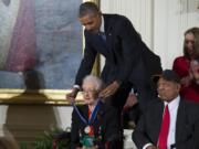 FILE - In this Nov. 24, 2015 photo, Willie Mays, right, looks on as President Barack Obama presents the Presidential Medal of Freedom to NASA mathematician Katherine Johnson during a ceremony in the East Room of the White House, in Washington. Johnson, a mathematician on early space missions who was portrayed in film &quot;Hidden Figures,&quot; about pioneering black female aerospace workers, died Monday, Feb. 24, 2020.