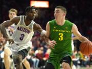 Oregon guard Payton Pritchard, right, drives on Arizona guard Dylan Smith during the first half of an NCAA college basketball game Saturday, Feb. 22, 2020, in Tucson, Ariz.