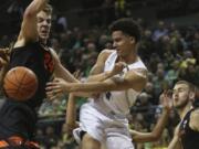 Oregon&#039;s Will Richardson, center, passes the ball between Oregon State&#039;s Kylor Kelley, left, and Tres Tinkle, right, during the first half of an NCAA college basketball game in Eugene, Ore., Thursday, Feb. 27, 2020.