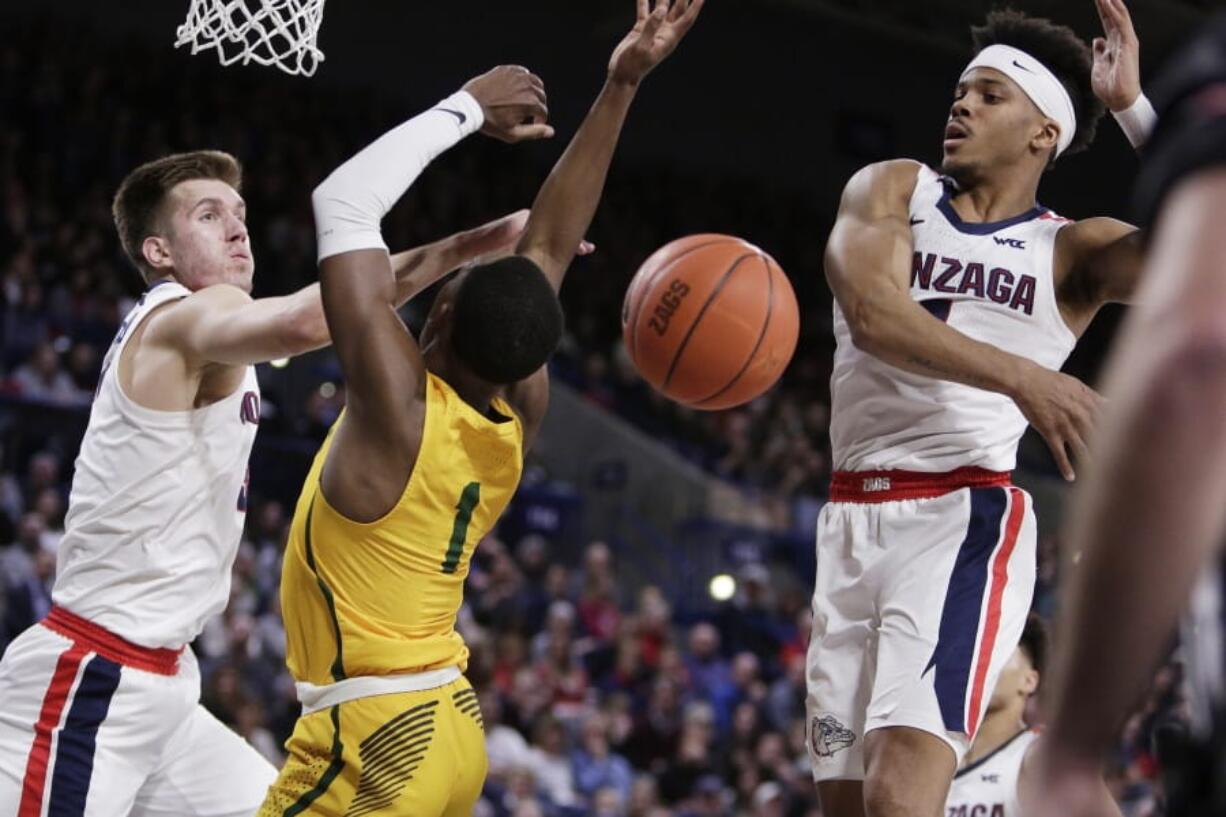 San Francisco guard Jamaree Bouyea, center, has his shot blocked by Gonzaga guard Admon Gilder, right, while also pressured by forward Filip Petrusev during the first half of an NCAA college basketball game in Spokane, Wash., Thursday, Feb. 20, 2020.