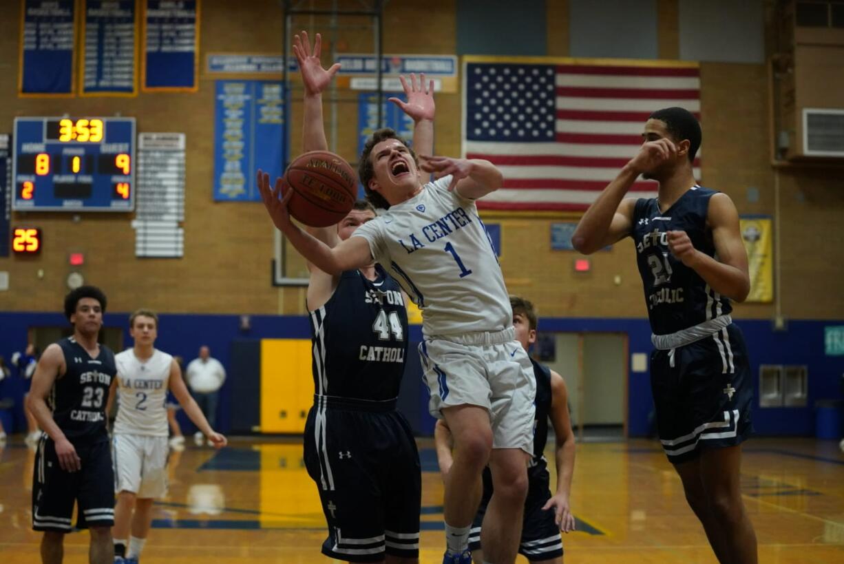 La Center's Hunter Ball (1) goes up for a shot against Seton Catholic's Griffin Young (44) and Xavian Rushing (right) in La Center's win over the Cougars.