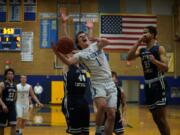 La Center's Hunter Ball (1) goes up for a shot against Seton Catholic's Griffin Young (44) and Xavian Rushing (right) in La Center's win over the Cougars.