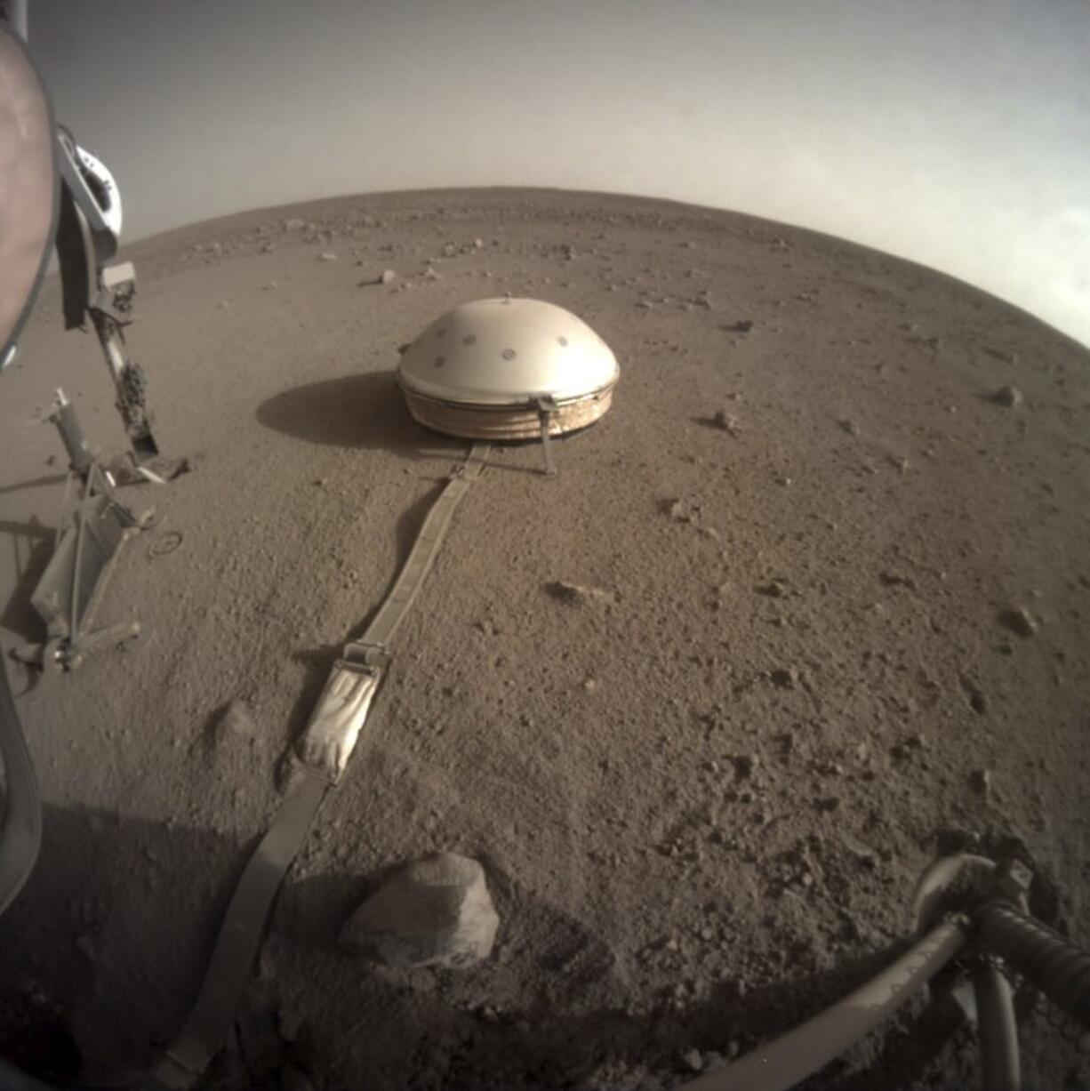 This Feb. 18, 2020 photo made available by NASA shows the InSight lander&#039;s dome-covered seismometer, known as SEIS, on Mars. On Monday, Feb. 24, 2020, scientists reported that the spacecraft has detected hundreds of quakes and even aftershocks that are regularly jolting the red planet.